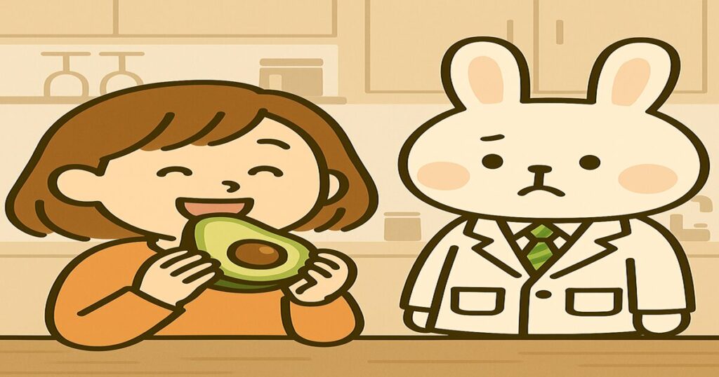キッチンの背景で、オレンジの服を着た女性（すずちゃん）が笑顔でアボカドを食べており、隣で白衣姿のうさぎ薬剤師（みどりん）がうらやましそうに横目で見ているイラスト。
